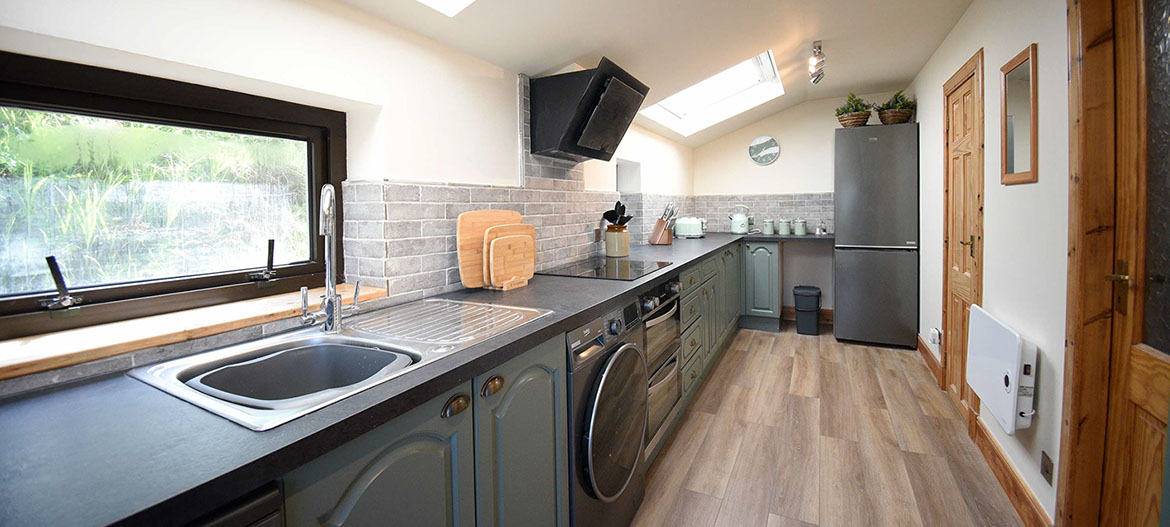 Caberfeidh Boat House contains a modern kitchen with washing machine oven hob fridge freezer kettle and microwave