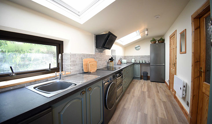 Caberfeidh Boat House contains a modern kitchen with washing machine oven hob fridge freezer kettle and microwave